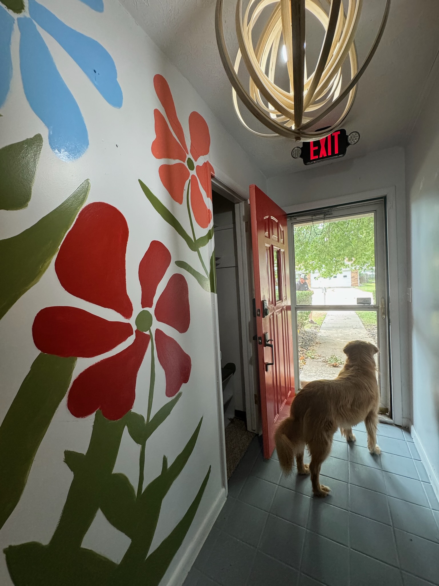 Front entrance of Heartland Suites Residential Assisted Living in Pryor, Oklahoma, featuring a hand-painted heart mural by the owner and the owner’s dog, welcoming residents.